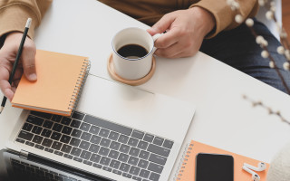 person holding white ceramic mug beside macbook pro 3787300