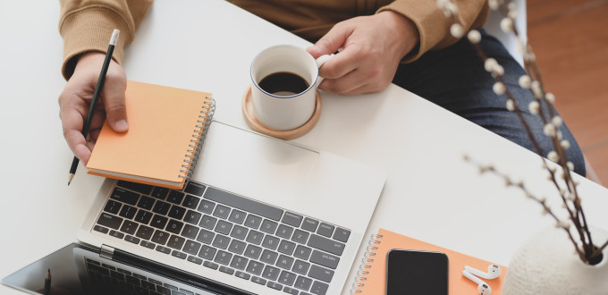 person holding white ceramic mug beside macbook pro 3787300